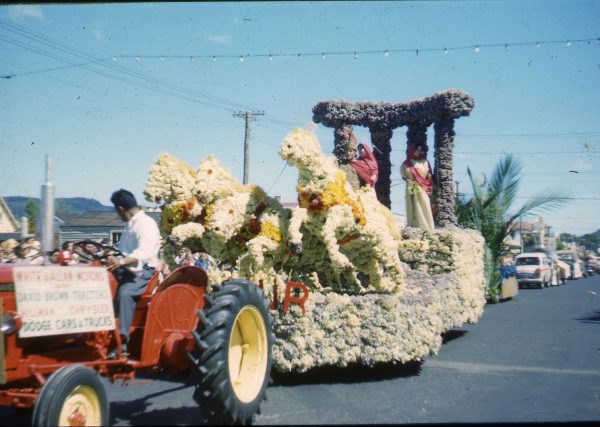 Man driving a tractor towing a float